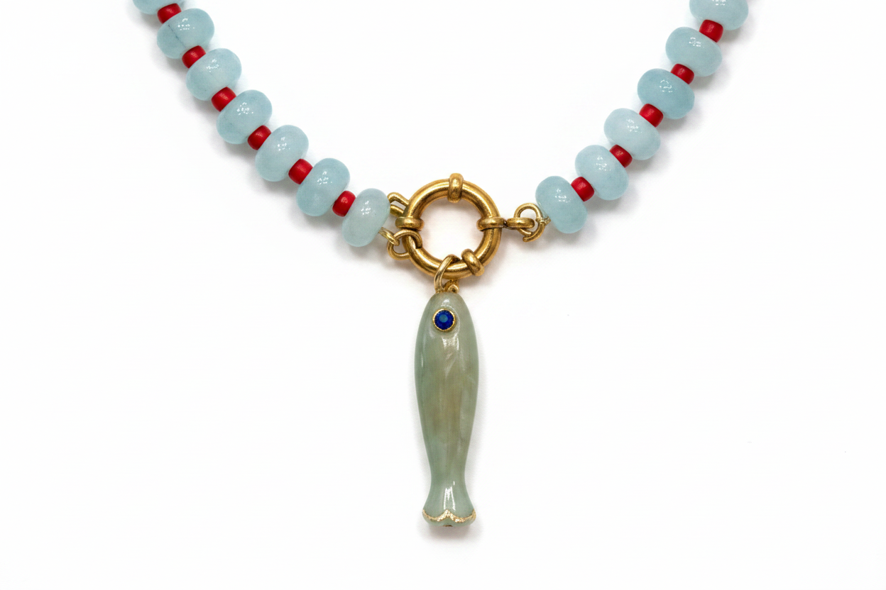 Close-up of gold clasp and light green fish charm